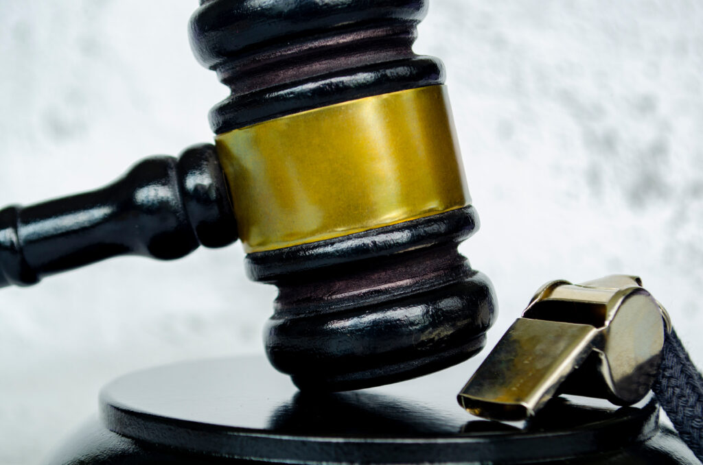 Closeup of a gavel next to a whistle.