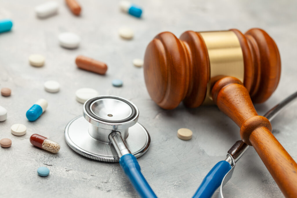 Gavel, stethoscope, and medicine tablets — illustrating the intersection of healthcare and medical malpractice law.