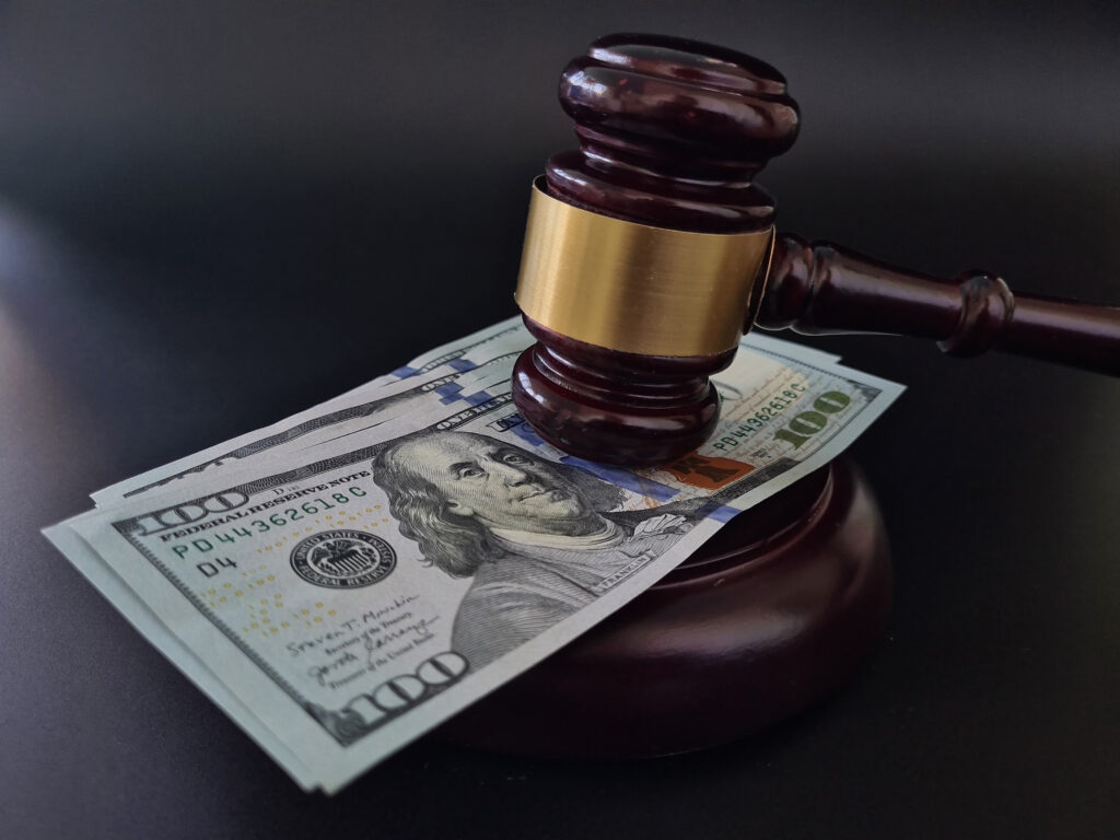 Gavel resting on a stack of one-hundred-dollar bills.